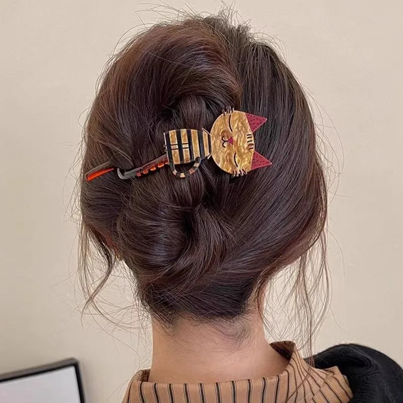 Woman with brown hair in a twist, secured with The Acrylic Cat Hairpin by KittyNook Cat Co., seen from behind.
