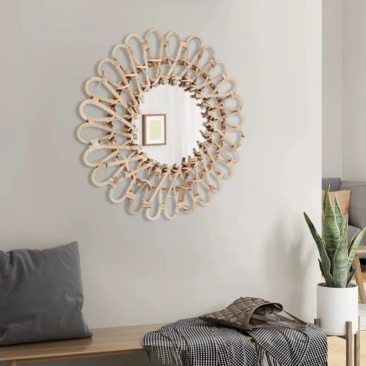 Rotan wandspiegel in hal met bank, plaid en monstera