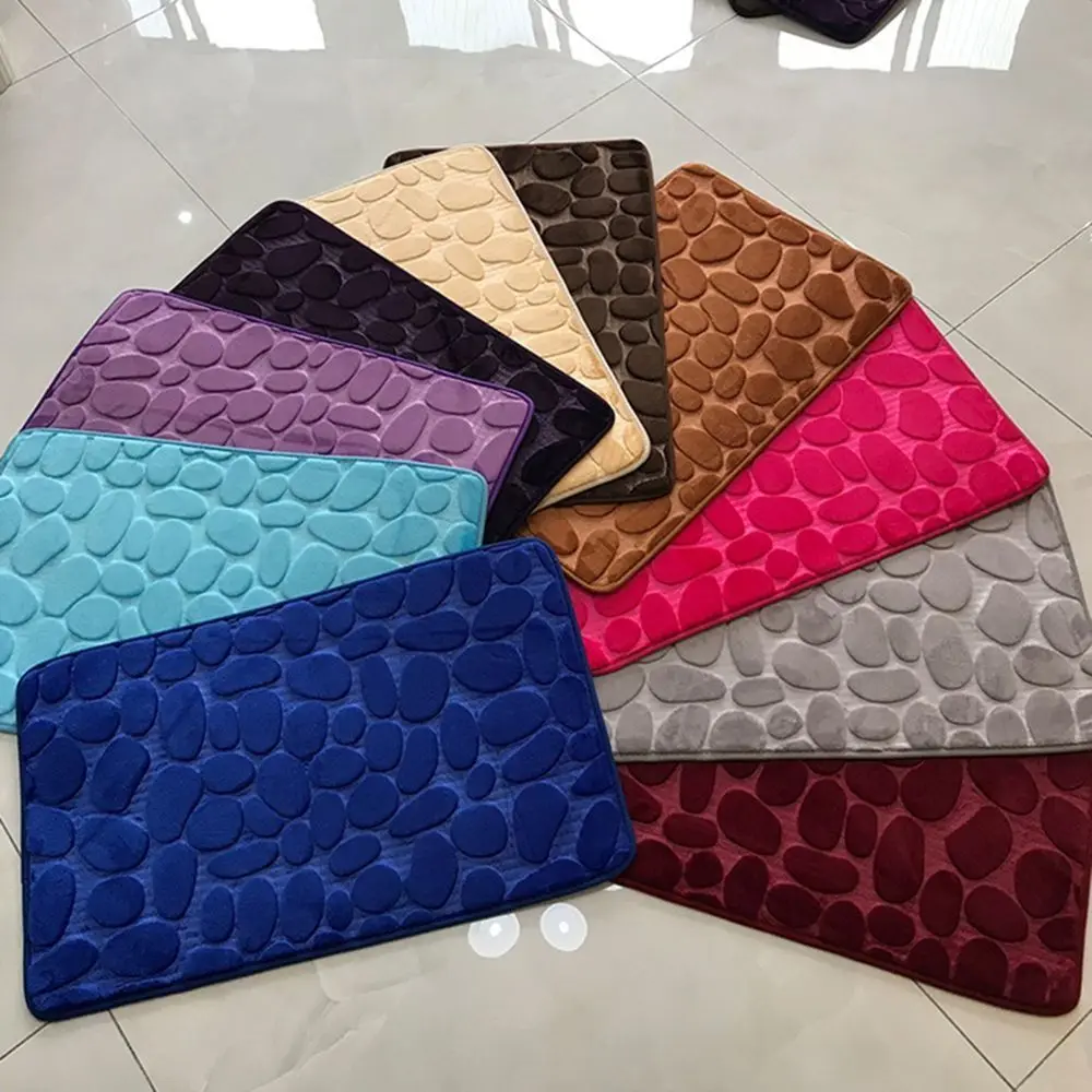 Cobblestone-textured gray bath mat with non-slip backing on a bathroom floor.