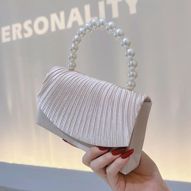 Elegant satin tote bag with pearl handle and ruffled edge design suitable for formal dinners and birthday parties