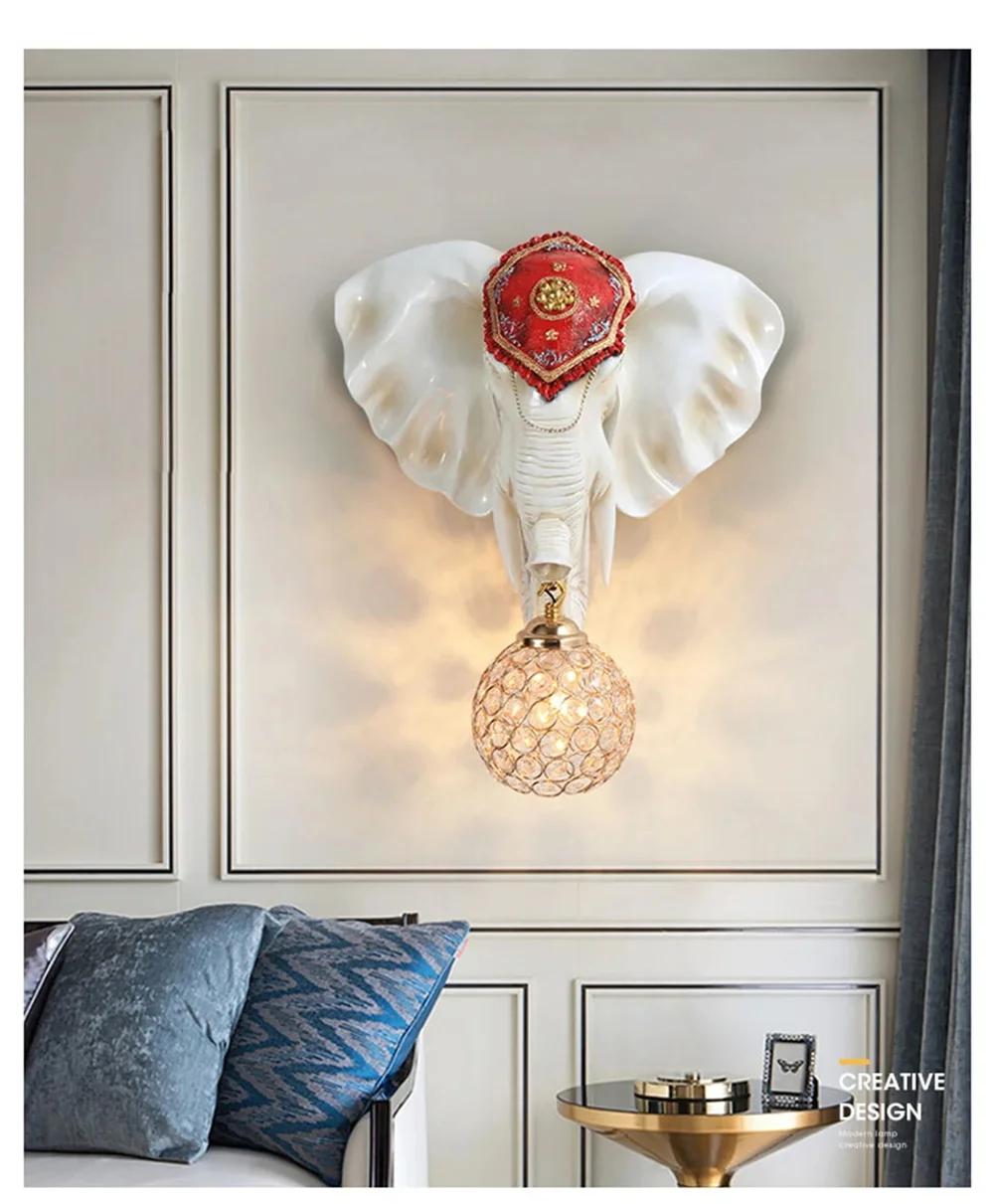 The 3D Elephant Wall Light, featuring a red hat and a spherical bulb, creates a unique ambiance as it adorns the paneled wall above the sofa and side table.