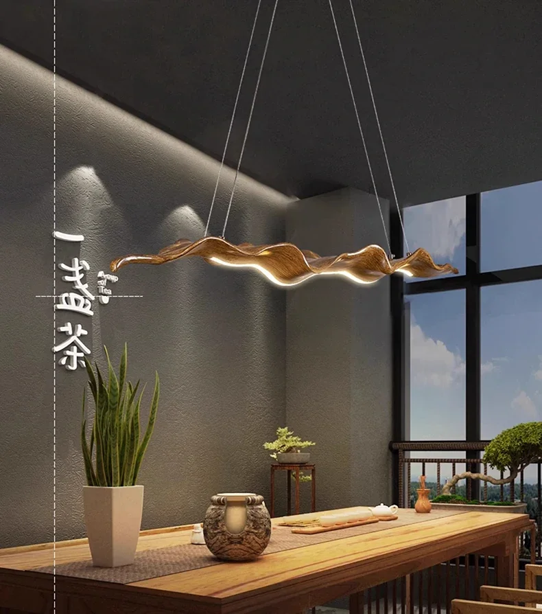 Elegant dining room featuring a Drift Wood Pendant Light, a wooden table, potted plants, and large windows overlooking an outdoor terrace.