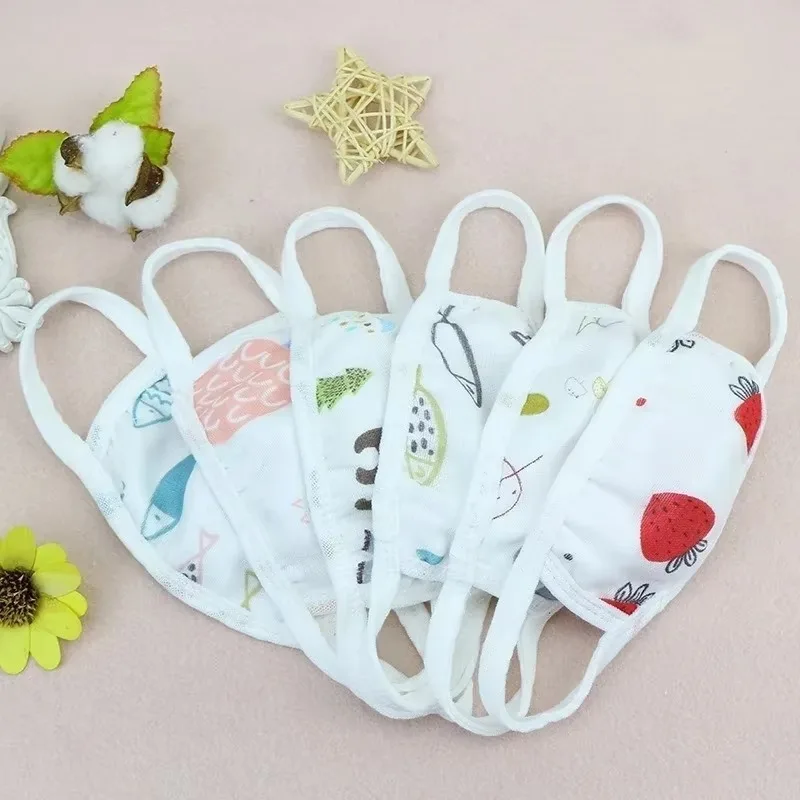Masque en gaze de coton 6 couches lavable et réutilisable pour enfant et adulte, posé à plat avec les attaches élastiques visibles