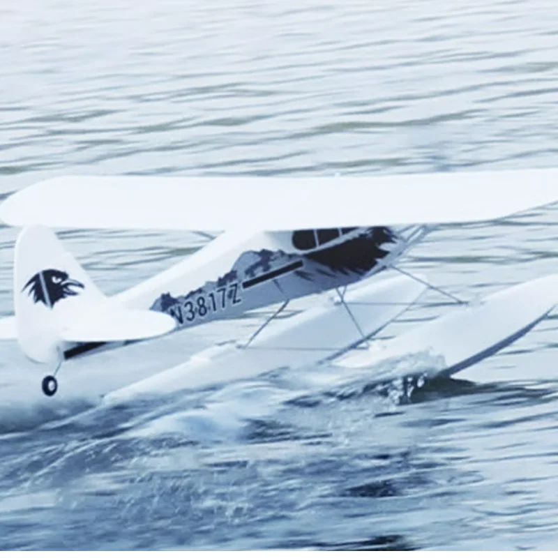 Avion RC PNP ou RTF 1300mm posé sur l'herbe, prêt à décoller.