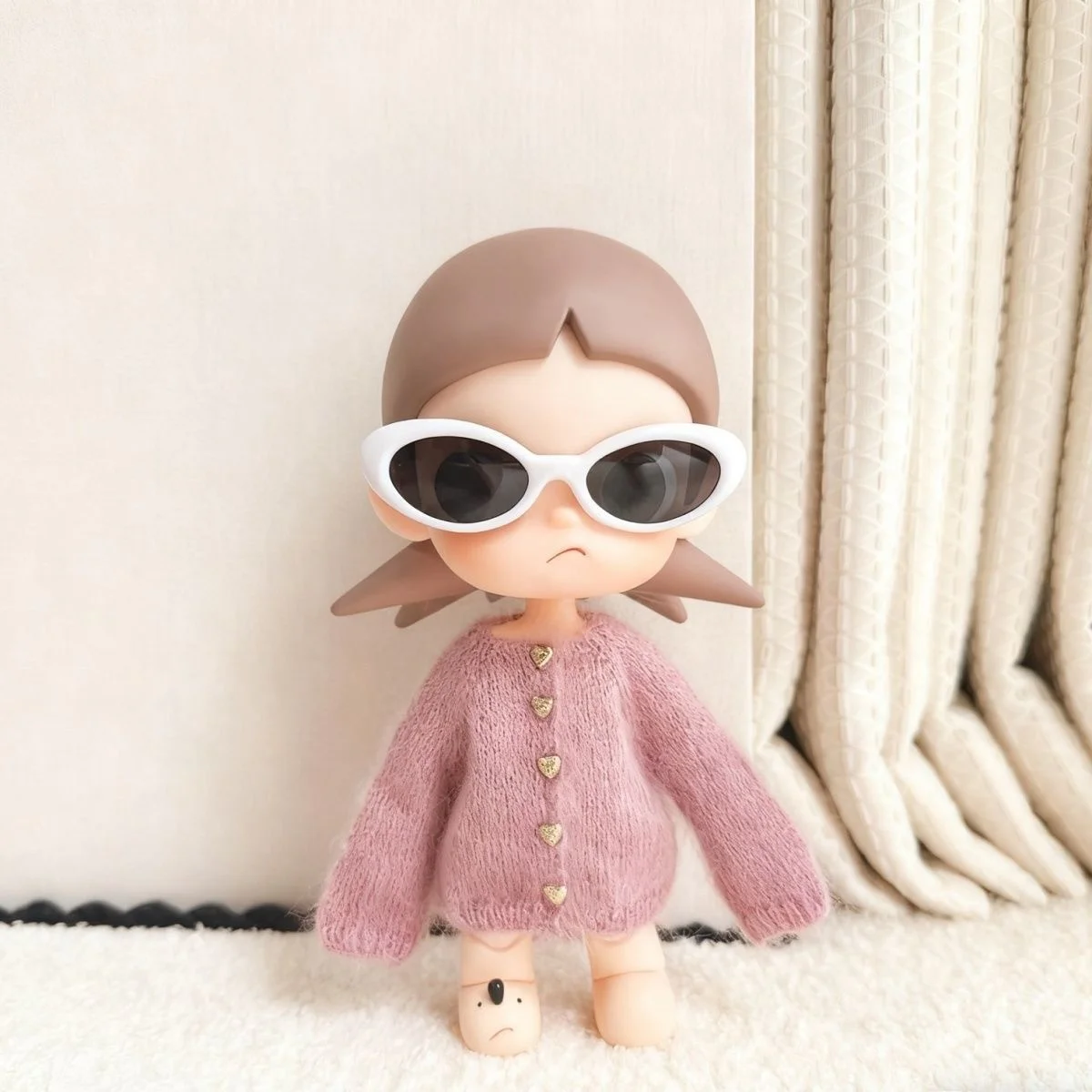 For the Zsiga doll dress it features a stylish pair of sunglasses a pink sweater and a cute design reminiscent of a grandma.