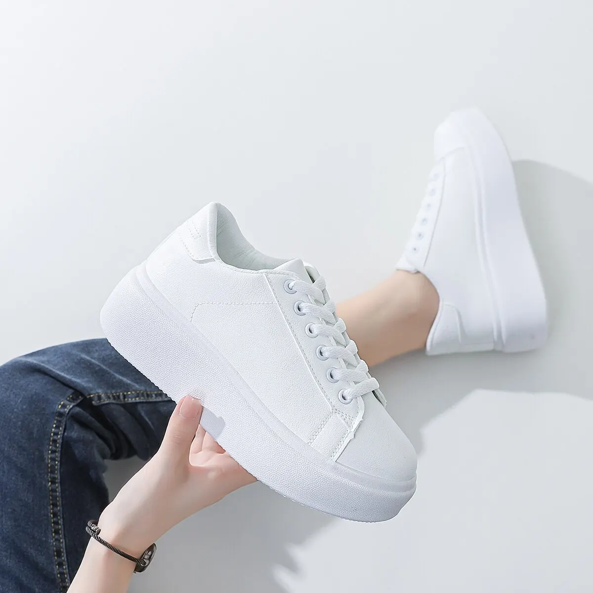 Caucasian woman hands tie elastic laces on chunky sole white sneakers shod  on her feet on the brown floor. New comfortable shoes for active lifestyle  Stock Photo - Alamy