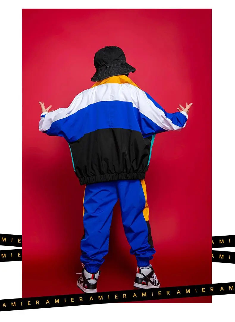 Child wearing patchwork jacket and joggers in hip hop street dance pose 652