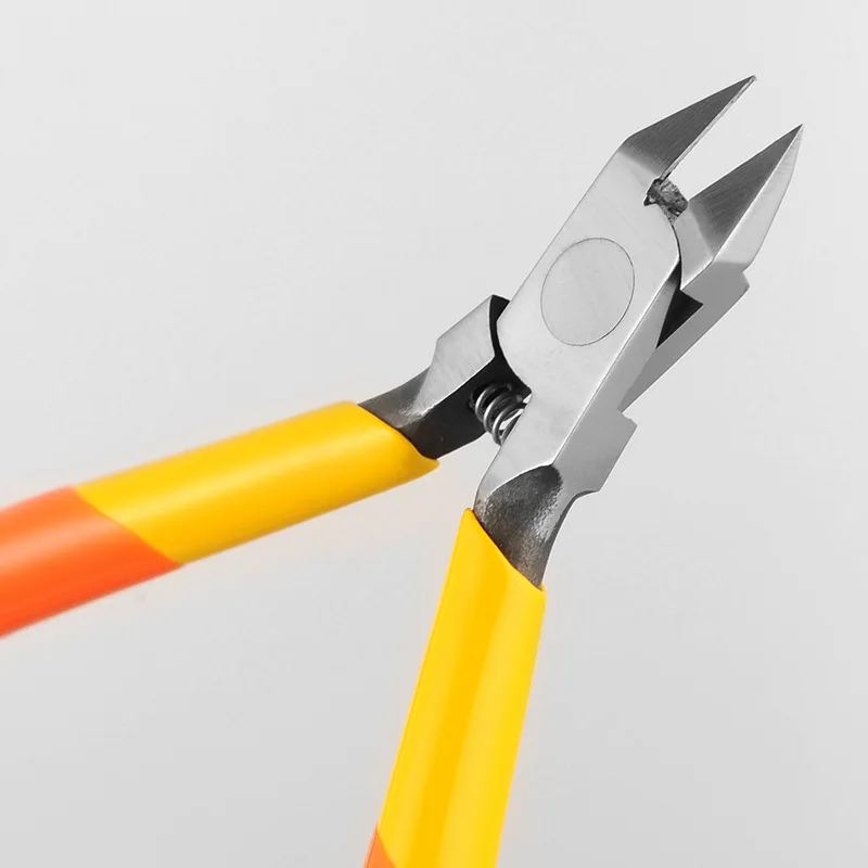 Gros plan sur les lames affûtées d'une pince coupante de précision professionnelle pour assemblage de modèles et puzzles.