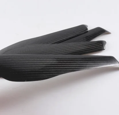 Quatre hélices carbone pour drone multirotor alignées sur fond blanc