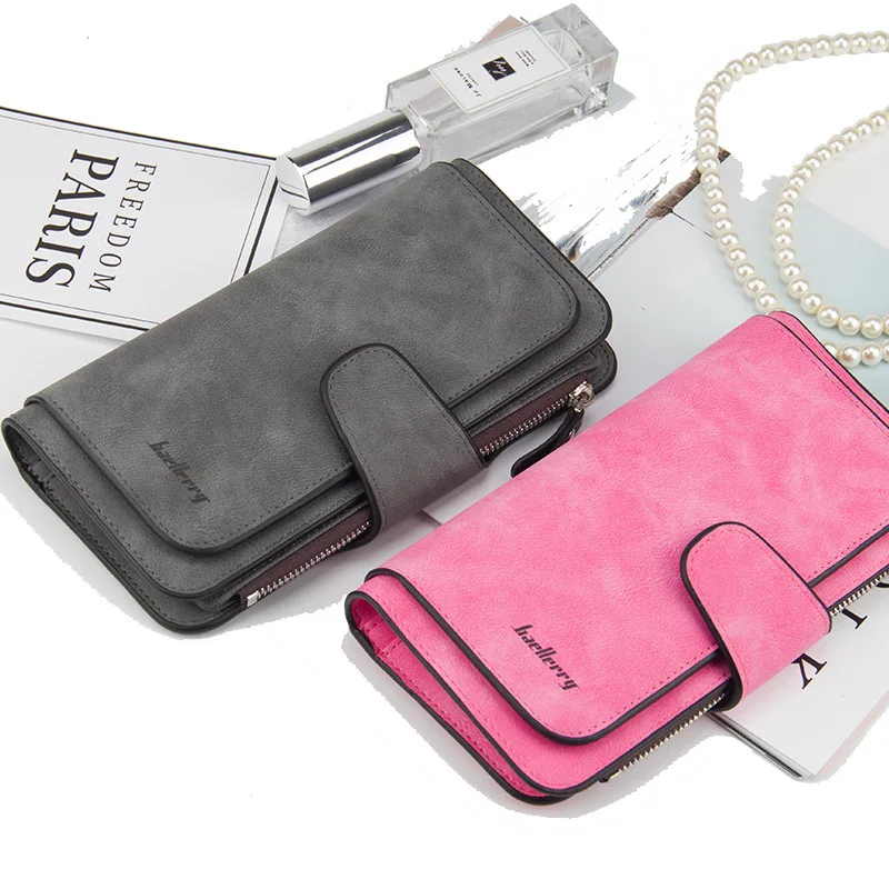 Two Luxury Fashion Womens Wallets featuring new fashion trends on a table next to each other.