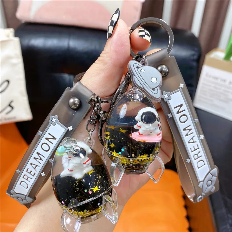 Cartoon Black Gold Astronaut Rocket Floating Bottle Portachiavi Cute Moving Play Guitar Spaceman Quicksand Liquid Key Chain Pendant