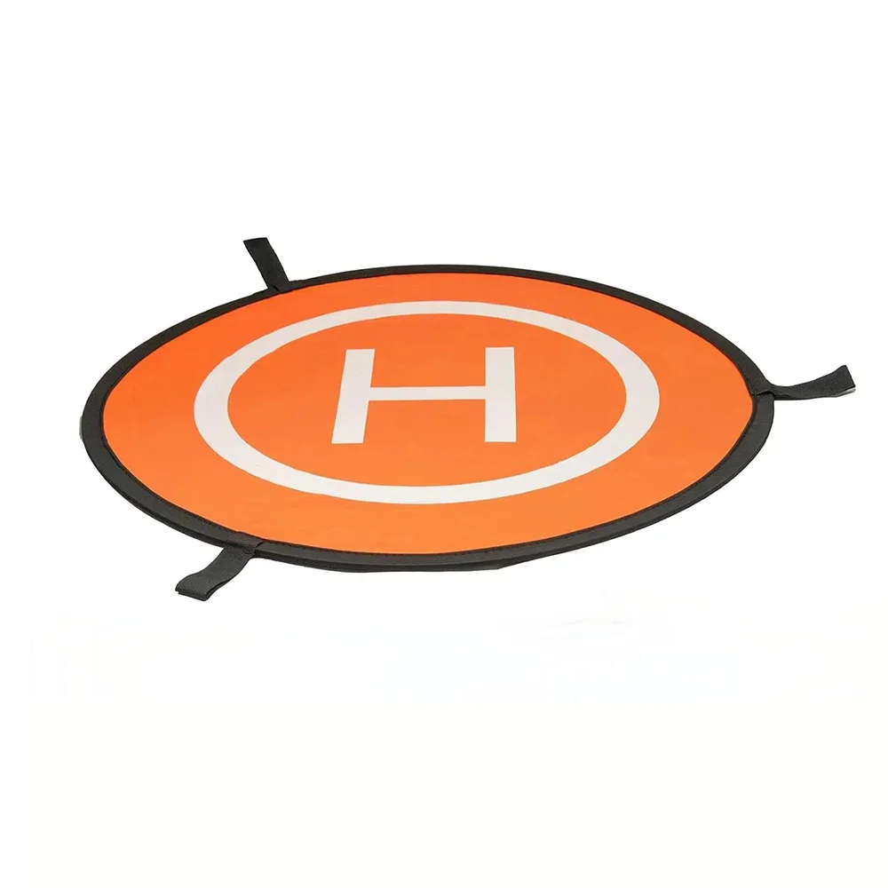 Drone DJI Air 3 en vol stationnaire au-dessus du tapis d'atterrissage orange, hélice en mouvement, fond de ciel bleu.