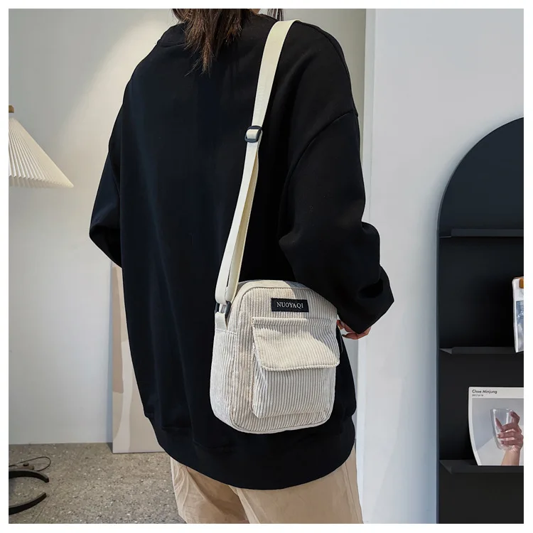 A stylish women’s corduroy shoulder bag with striped fabric design, zip closure, and canvas crossbody strap beige