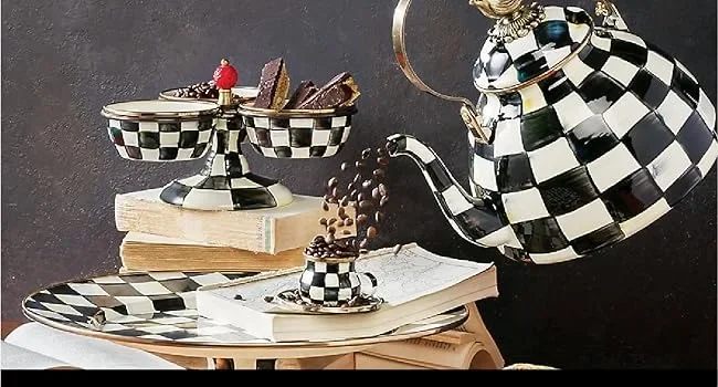 A tea kettle pot pouring tea into a cup.