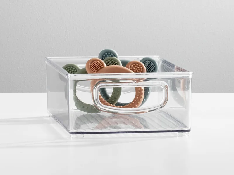 clear plastic baby bin with d shaped handle holding teethers