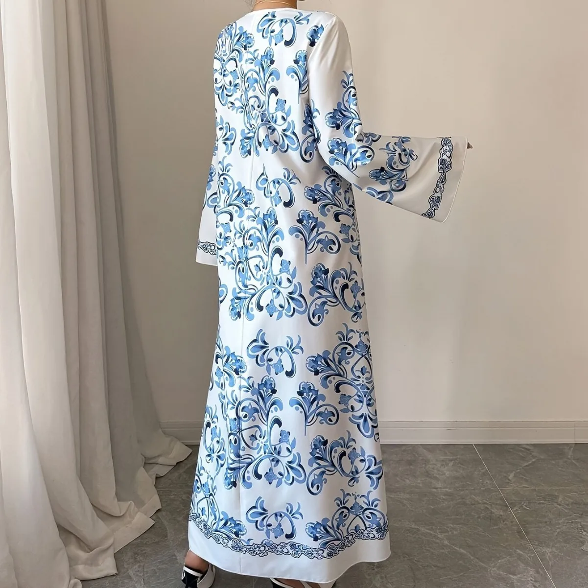 جلابية بيضاء طويلة بنقوش زرقاء وأكمام واسعة