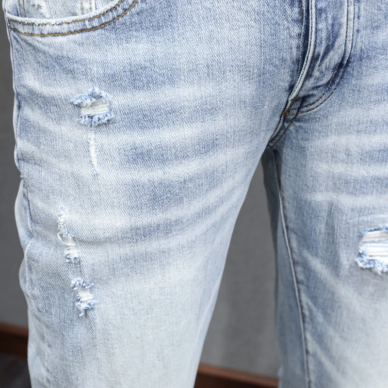 The latest designer's fashionable new men's jeans are washed, elastic, slim fit, light blue slit jeans, high street trendy hip-h